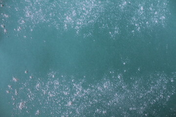 Background meal flour or powdered sugar scattered on a mint blue green background with a copypeist eat for text