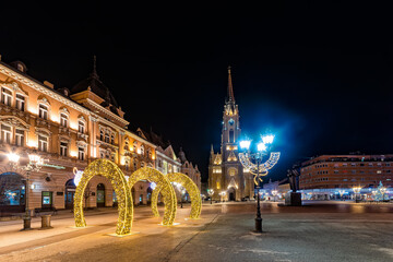 Fototapeta na wymiar Novi Sad, Serbia January 05, 2021: Holy Mary church landmark in city center with christmas lights in Novi Sad, Serbia.