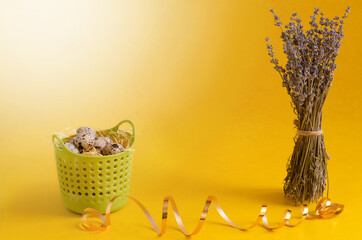 eggs in a basket and paints lie on a yellow table. preparing for Easter