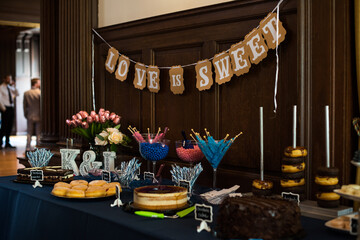 dessert Table at a Party or wedding with lost of blue and pink colors and wooden wall