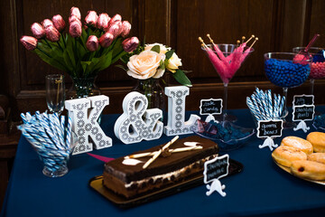 dessert Table at a Party or wedding with lost of blue and pink colors and wooden wall