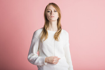Fototapeta premium Portrait of a beautiful woman on a pink background in the studio