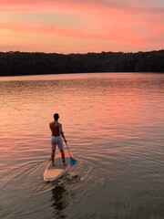 silhouette of a person on a sunset using a SUP board