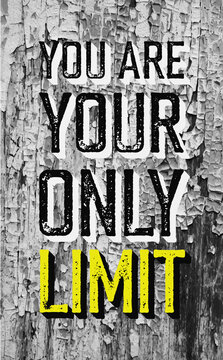 Motivational phrase "You are your only limit" on old cracked paint on the wooden wall texture.