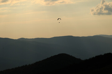 Paraglider silhouette at sunset in Bieszczady Mountains, Poland © bayazed