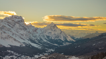 Early morning winter panorama of Valley around Cortina d'Ampezzo viewed from Tofana or ski piste above Cortina. Majestic mountains rising from the valley in sunrise.