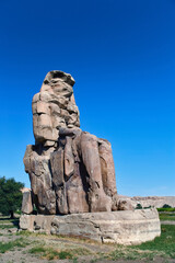 Fototapeta na wymiar Colossi of Memnon, two statues of Pharaoh Amenhotep III on the West Bank, near modern day Luxor, or ancient Thebes.