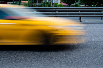 Motion blurred yellow taxi car on a road