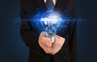 Businessman holding light bulb with INTERNET inscription, innovative technology concept