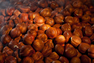 Peeled hazelnuts close up. Texture of nuts. Lots of nuts in a pile. Contrasting dramatic light as an artistic effect.