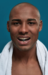 Fototapeta premium Bald male biting a tablet standing in his teeth