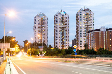 Modern city high-rise buildings and road traffic at night