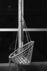 Hanging rocking chair hanging in front of the panoramic window