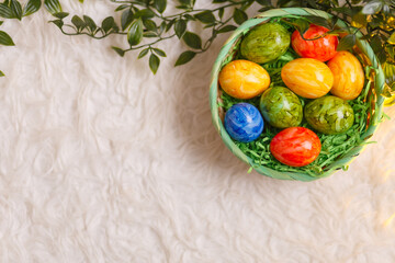 Easter card. Flat lay composition with easter eggs in a basket on white background.