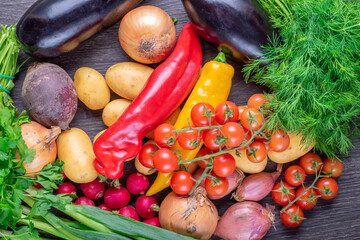 Fresh colorful organic vegetables on a rustic wooden table background.