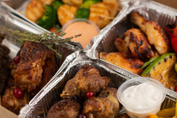 Various types of fried pork, chicken and beef meat are in food boxes.