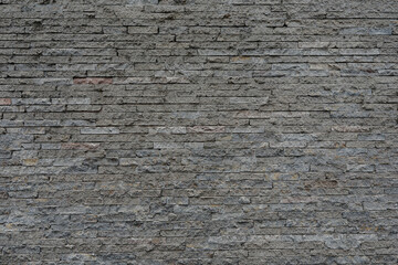 Rough and uneven brick wall with cracked and uneven stones, space for text, no people and horizontal