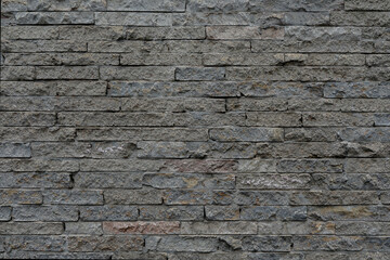 Grey rough brick wall with small stones, empty wall with space for text, no person