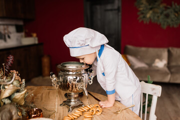 Portrait of a little boy cook at kitchen. Different occupations. Isolated over white background.