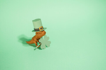 Dinosaur leprechaun in green hat with paper clover. Saint Patrick's Day banner. Funny greeting card
