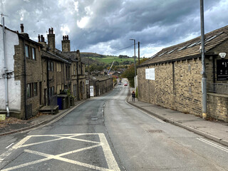 Looking along, Burnley Road, with old buildings, distant hills, and heavy rain clouds above in, Mytholmroyd, Sowerby Bridge, UK