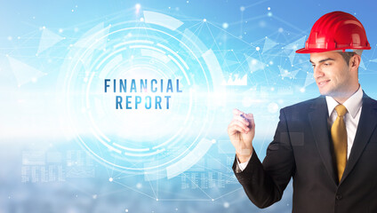 Handsome businessman with helmet drawing FINANCIAL REPORT inscription, contruction business concept