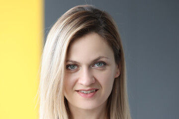 Fototapeta premium Portrait of smiling woman on gray background