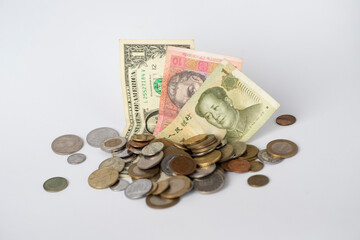 Paper money dollars, hryvnias, yuan and various coins are on a white background