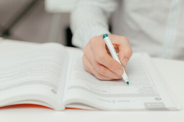 male hand with felt-tip pen writes notes in notebook