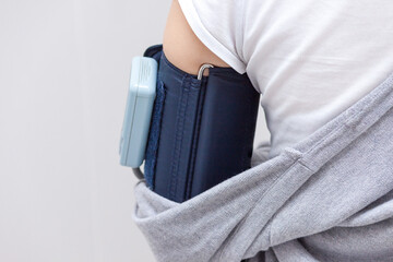 Woman wearing holter monitor device for daily monitoring the pressure