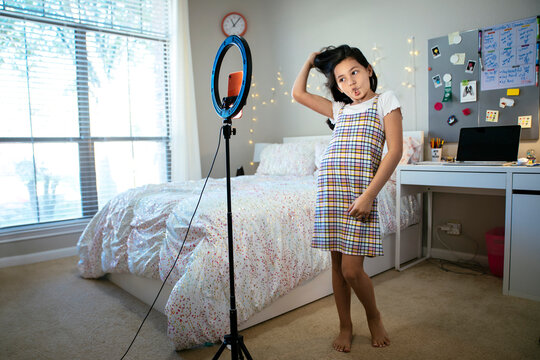 Happy Tween Girl Making Dancing Video For Tiktok Social Media On Cell Phone In Bedroom