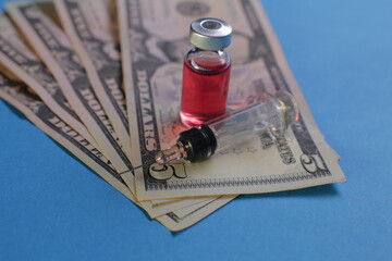 Syringe vial with vaccine and american dollars on blue background