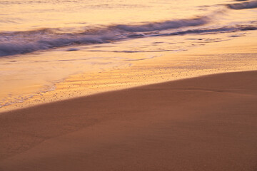 Fototapeta na wymiar Sandy tropical beach at sunset as a backdrop.