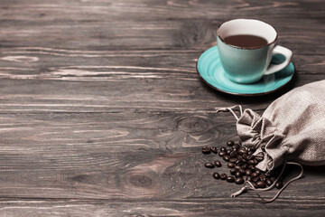 Fototapeta na wymiar Coffee beans and coffee cup on wooden background.Copy space.