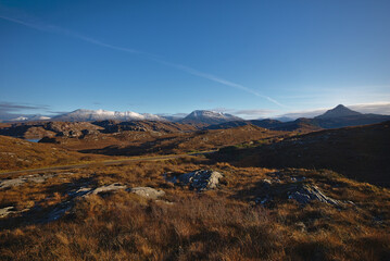 Obraz premium Snow on the mmountains from the A838 North of Scourie, Sutherland, North West Scotland, UK
