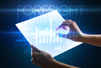 Hand holding futuristic tablet with FORESIGHT inscription above, modern business concept