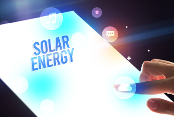 Holding futuristic tablet with SOLAR ENERGY inscription, new technology concept