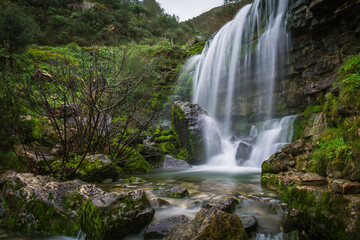 Fototapeta na wymiar Beautiful waterfall in the mountains of Serra de Aire, Portugal. Long exposure of the waterfall of Fornea in Porto de Mos, Portugal. 