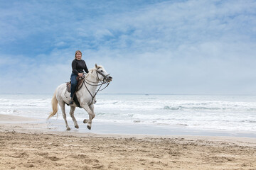 young woman on a horse on the beach