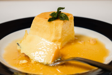 Eating the delicious typical Argentine and South American dessert called Flan with caramel. The diner's hand is observed. Natural and healthy eating concept.