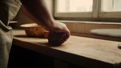 Man getting ready for handicraft in pottery. Ceramist sculpting piece of clay