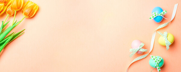 Easter bunny. Colourful egg with tape ribbon, spring tulips, feathers on pastel pink background in Happy Easter decoration. Traditional banner in top view.