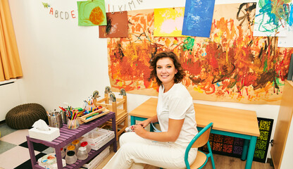 Young artist teacher in art classroom in kindergarten or primary school