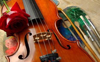 violin, red rose, palette and brushes. close-up