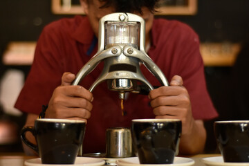 Barista cafe Prepare espresso and vietnam coffee drinks at the coffee shop. portrait of a coffee shop employee making coffee at the bar. the process of making warm drinks with a vintage color concept