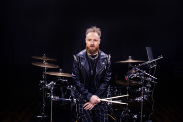 brutal portrait of a man musician with a beard and in black clothes on the background of musical...
