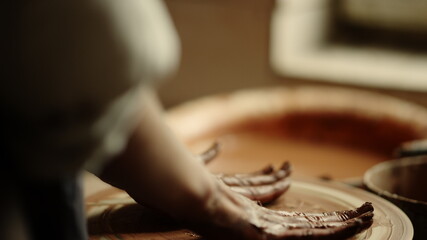 Fototapeta na wymiar Lady ending handicraft process in pottery. Woman hands having rest in workshop