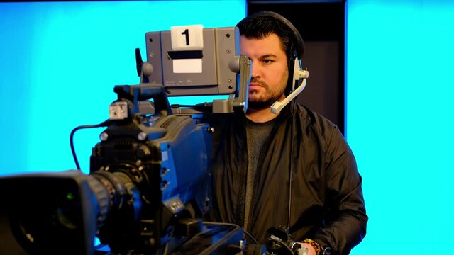 Professional cameraman with headphones with HD camcorder in live television	