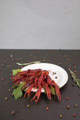 Delicious boiled crayfish close-up on a white plate, with pepper, lemon and parsley. free space for your text.