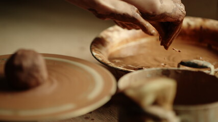 Unknown woman preparing hands for sculpting in workshop. Girl modeling clay